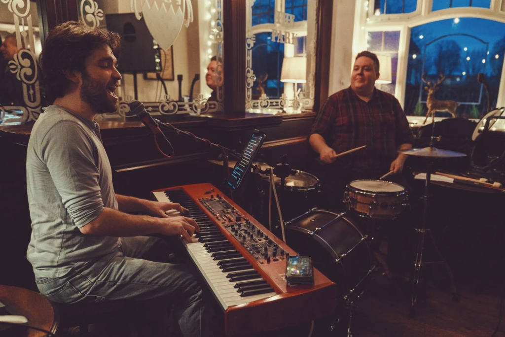 Al Kronka performing with a drummer in a pub as part of a live music duo.