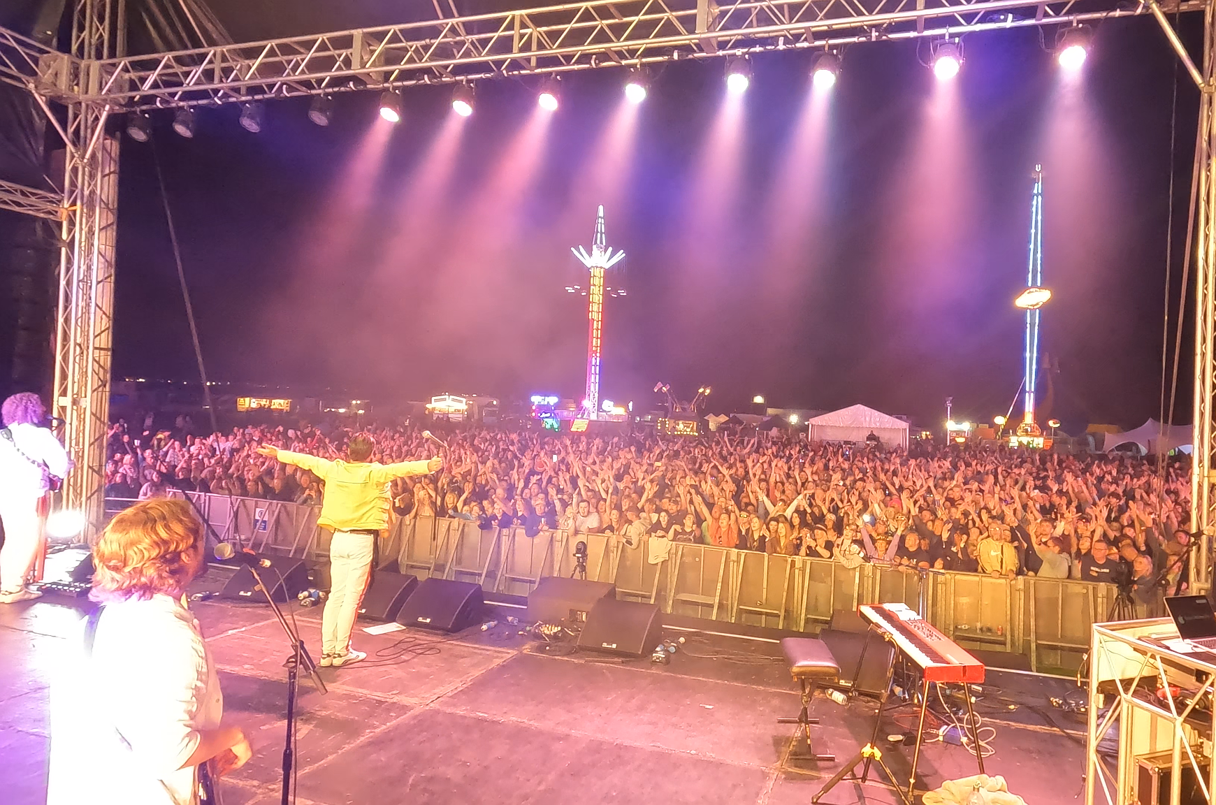 UK Queen tribute band lead singer Al Kronka with arms outstretched, engaging the crowd at Poole Harbour Festival.